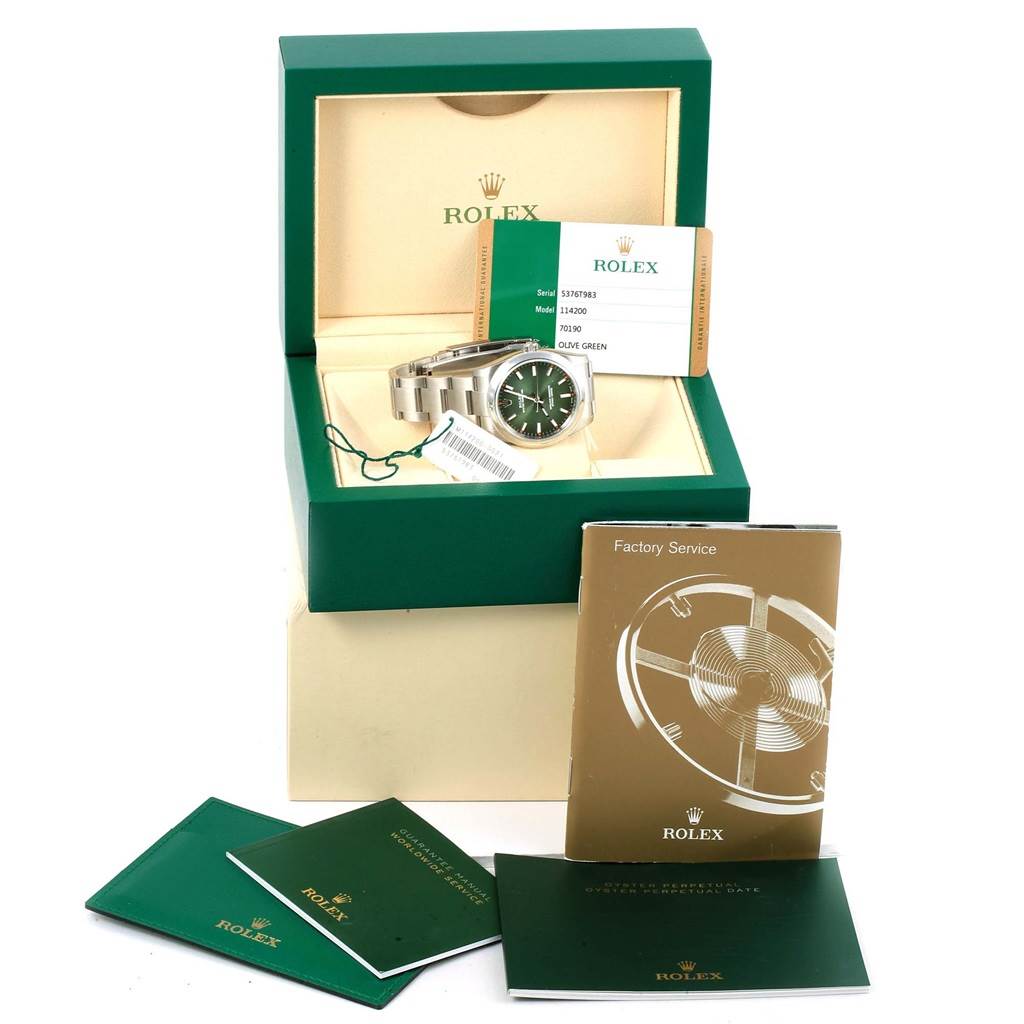 The image shows a Rolex Oyster Perpetual 114200 Stainless Steel Green Dial 114200 Stainless Steel Green Dial watch with an olive green dial, box, and accompanying booklets viewed from the front.