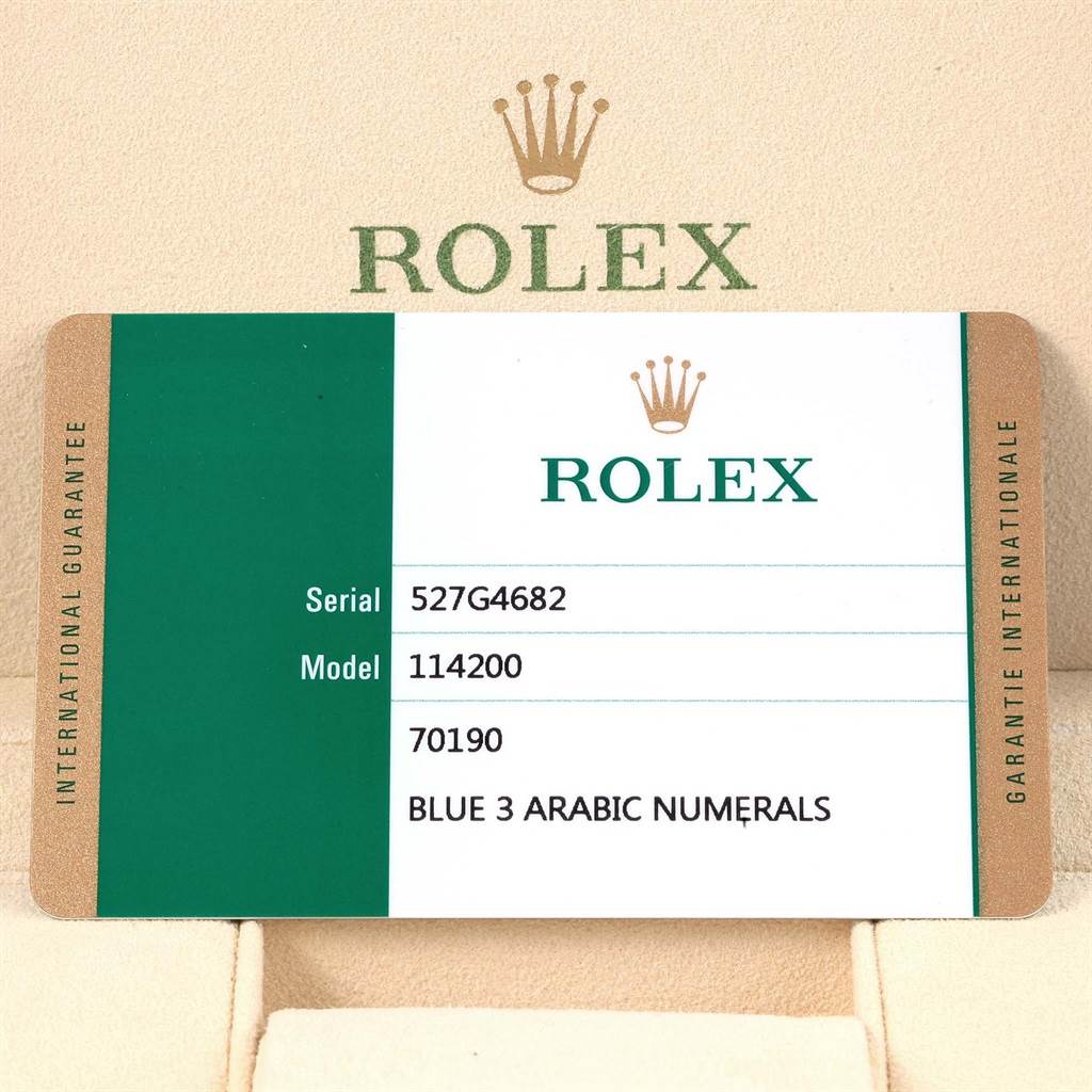 This image shows the warranty card for a Rolex Oyster Perpetual 114200 Men's Stainless Steel Blue Dial 114200 Men's Stainless Steel Blue Dial model 114200 with blue 3 Arabic numerals.
