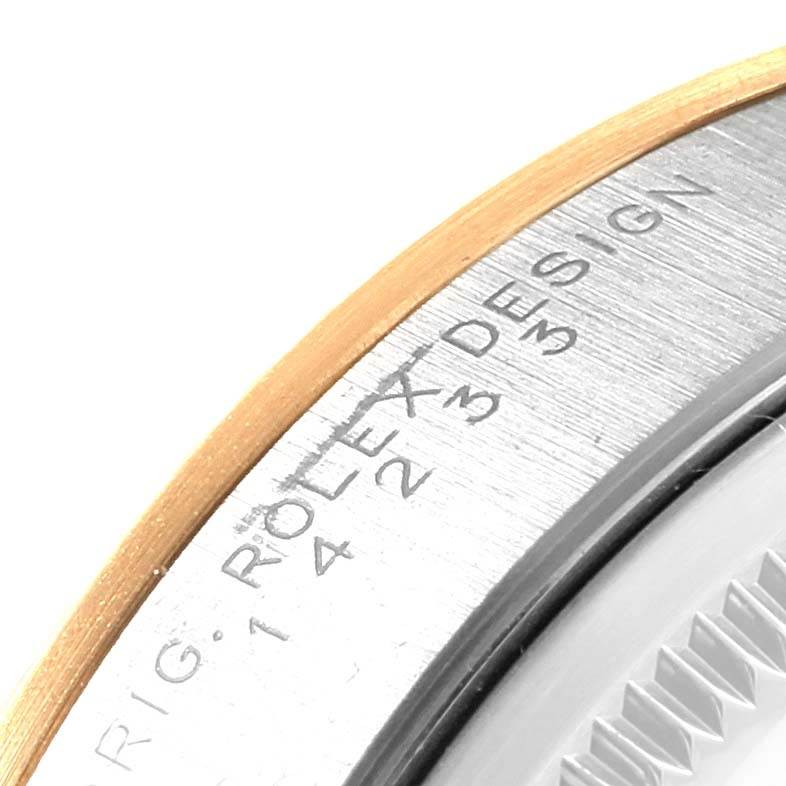 The image shows a close-up of the bezel and edge of the dial of a Rolex Oyster Perpetual 14233 Men's Steel and Gold (two tone) White Dial 14233 Men's Steel and Gold (two tone) White Dial watch, highlighting part of the engraving.