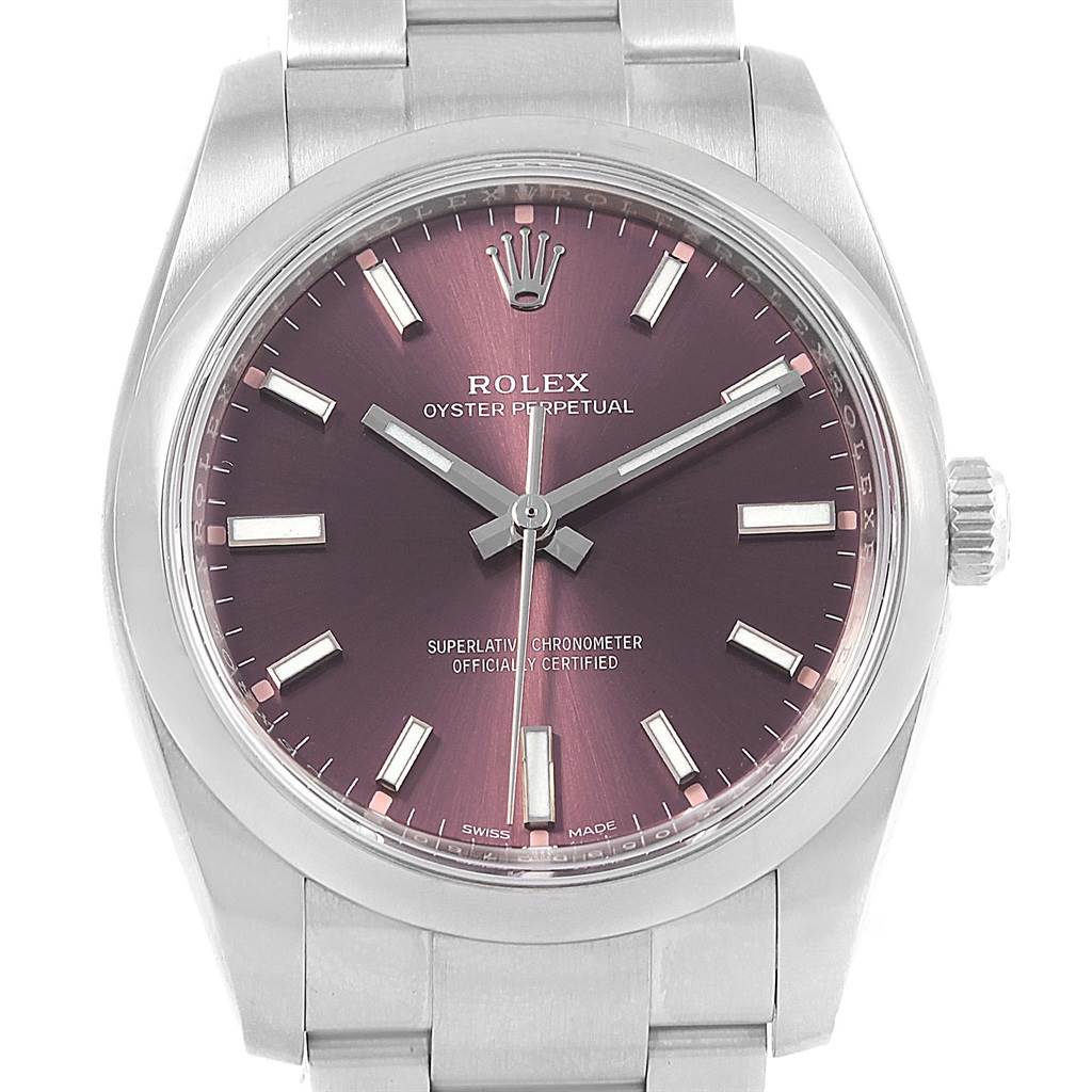 The image shows a frontal view of a Rolex Oyster Perpetual 114200 Stainless Steel Burgundy Dial 114200 Stainless Steel Burgundy Dial watch with a purple dial, hour markers, hands, and crown.