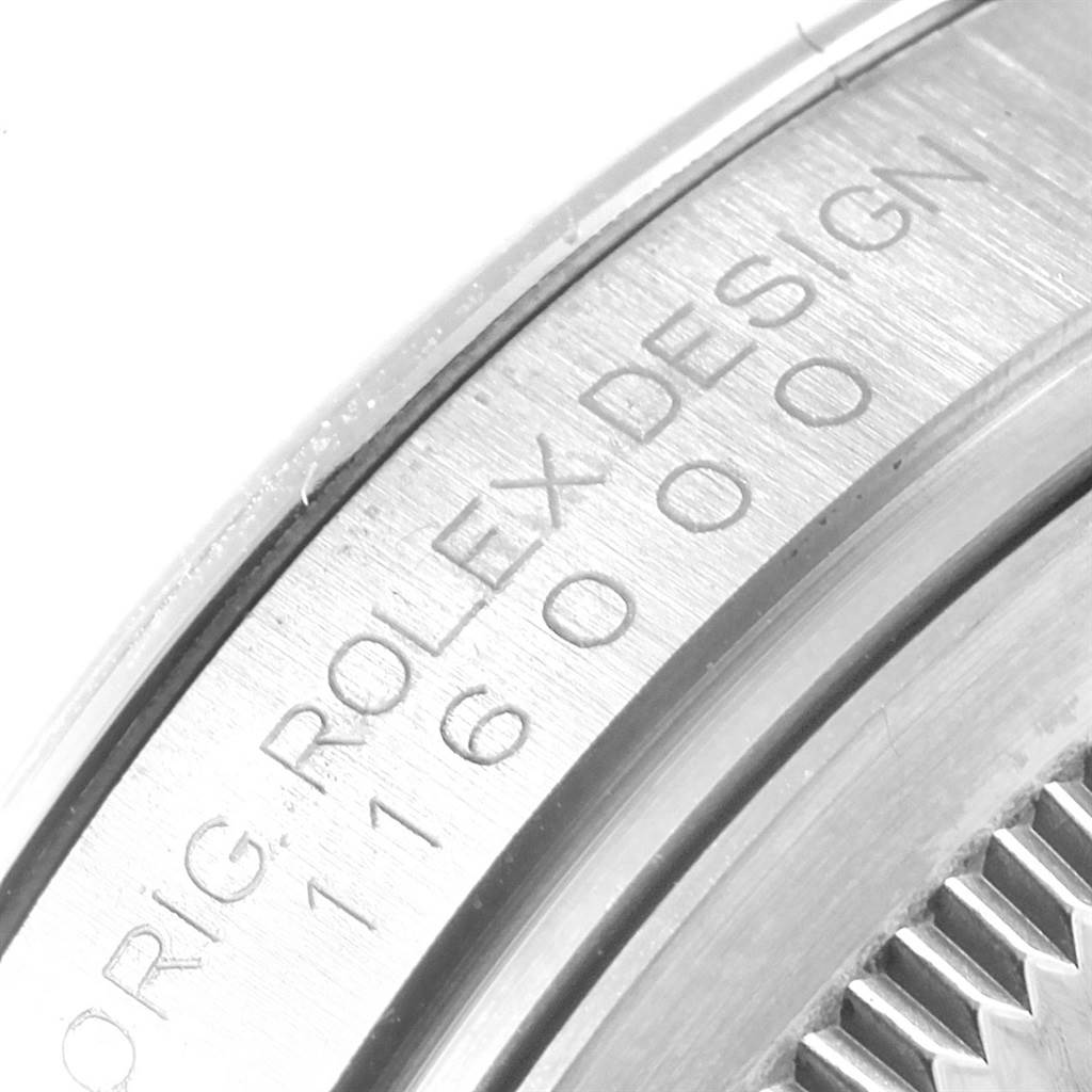 This close-up angle shows the engraved side of the Rolex Oyster Perpetual 116000 Men
s Stainless Steel Silver Dial 116000 Men
s Stainless Steel Silver Dial watch, highlighting the "ROLEX DESIGN" and model number.