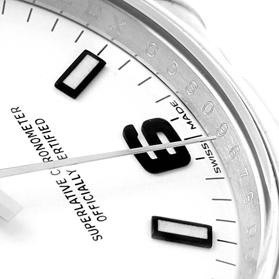 This close-up angle displays the dial, numerical hour marker, and part of the rehaut of the Rolex Oyster Perpetual 114200 Men
s Stainless Steel White Dial 114200 Men
s Stainless Steel White Dial watch.