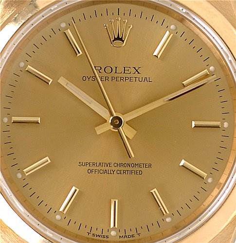 This image shows a close-up of the dial of a Rolex Oyster Perpetual 14208 Men
s Yellow Gold Champagne Dial 14208 Men
s Yellow Gold Champagne Dial watch, highlighting the hands, indices, and logo.