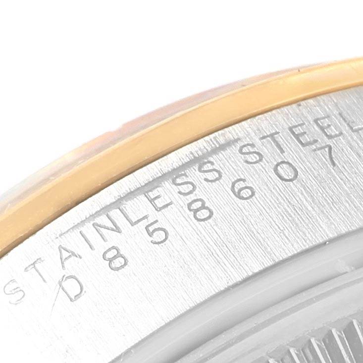 The image shows a close-up of the edge of the back case and bezel of a Rolex Oyster Perpetual 15203 Men's Steel and Gold (two tone) Grey Dial 15203 Men's Steel and Gold (two tone) Grey Dial watch with stainless steel markings.