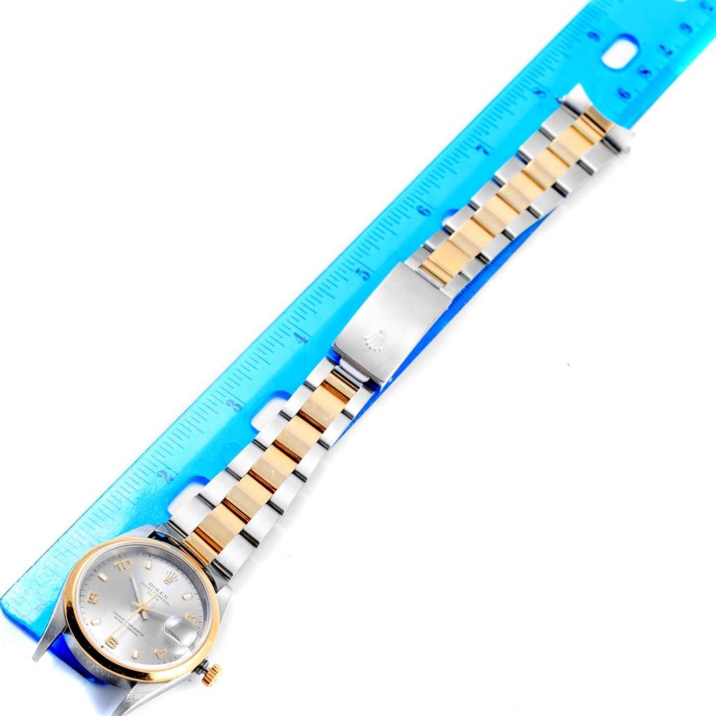 The image shows the front view of a Rolex Oyster Perpetual 15203 Men's Steel and Gold (two tone) Grey Dial 15203 Men's Steel and Gold (two tone) Grey Dial watch alongside a blue ruler for scale.