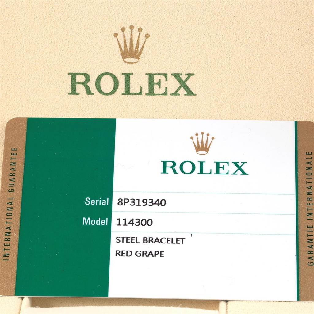 The image shows the guarantee card for the Rolex Oyster Perpetual 114300 Stainless Steel Burgundy Dial 114300 Stainless Steel Burgundy Dial model 114300 with a steel bracelet and red grape dial.