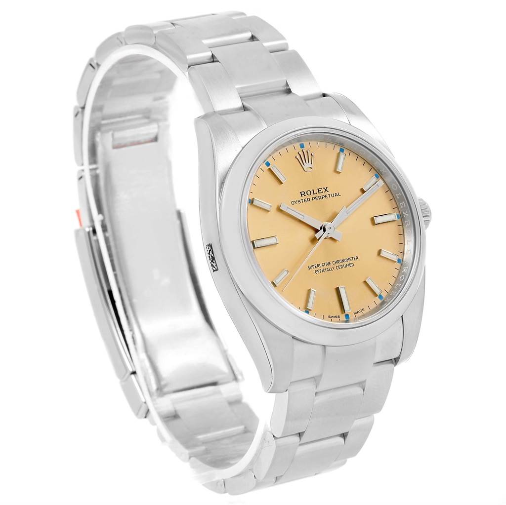 The Rolex Oyster Perpetual 114200 Stainless Steel Champagne Dial 114200 Stainless Steel Champagne Dial watch is shown at a 3/4 angle highlighting its face, bracelet, and clasp.
