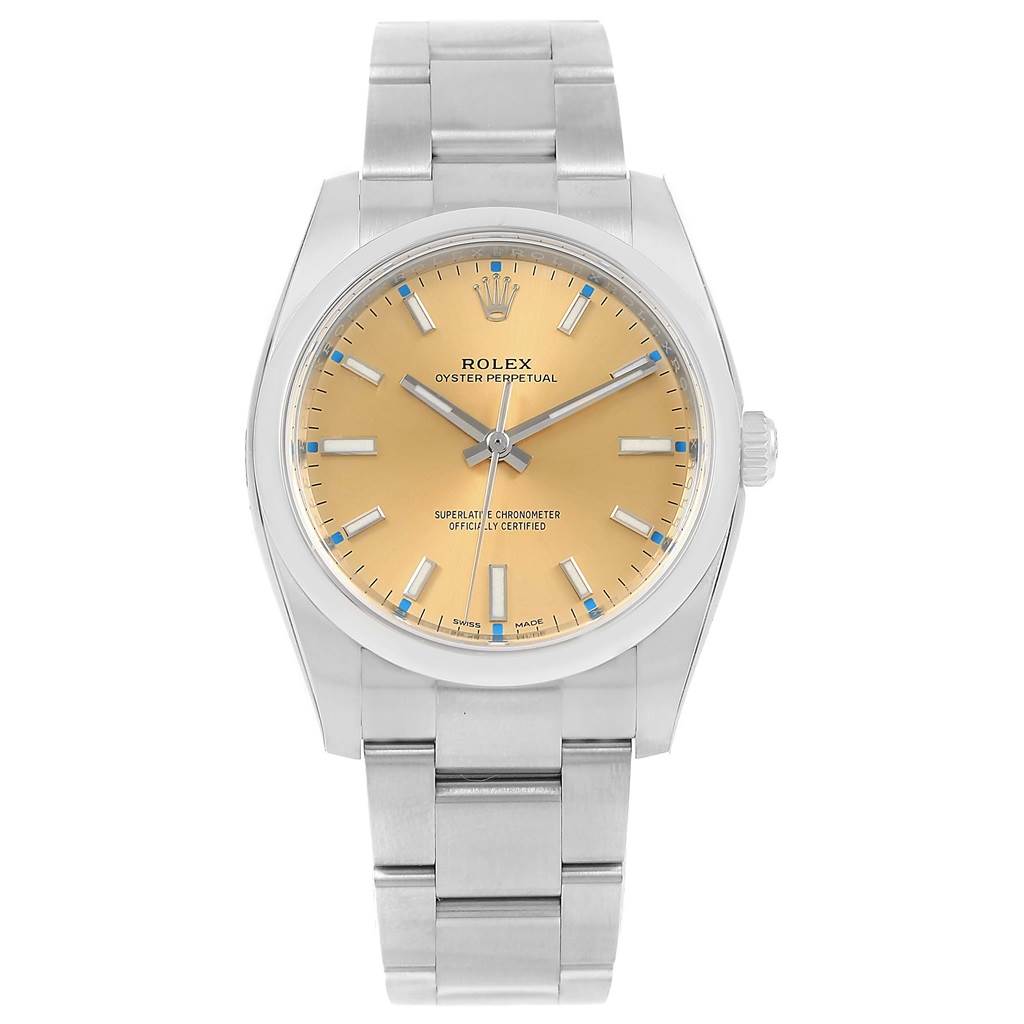 The image shows a front view of a Rolex Oyster Perpetual 114200 Stainless Steel Champagne Dial 114200 Stainless Steel Champagne Dial watch with a metallic bracelet and a yellow dial.