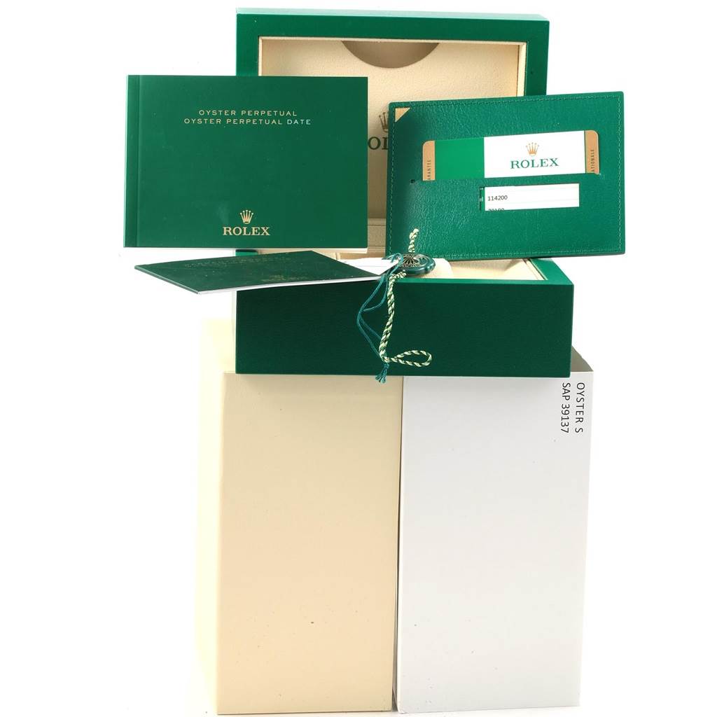 The image shows the packaging, documentation, and warranty card for a Rolex Oyster Perpetual 114200 Men's Stainless Steel Blue Dial 114200 Men's Stainless Steel Blue Dial watch.