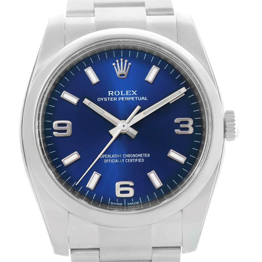 The image shows a front view of a Rolex Oyster Perpetual 114200 Men's Stainless Steel Blue Dial 114200 Men's Stainless Steel Blue Dial watch featuring a blue dial and silver bracelet.