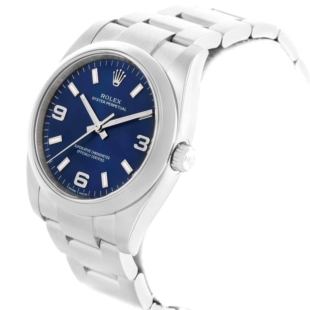 This image shows a side angle view of the Rolex Oyster Perpetual 114200 Men's Stainless Steel Blue Dial 114200 Men's Stainless Steel Blue Dial watch, highlighting its blue dial, crown, and bracelet.