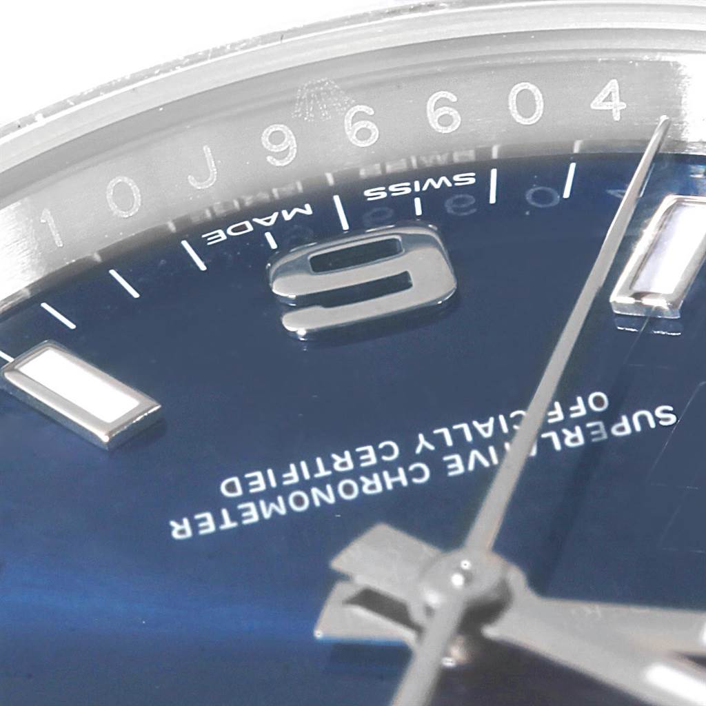 This close-up of a Rolex Oyster Perpetual 114200 Men's Stainless Steel Blue Dial 114200 Men's Stainless Steel Blue Dial watch shows the blue dial, hour markers, minute hand, and "Swiss Made" inscription.