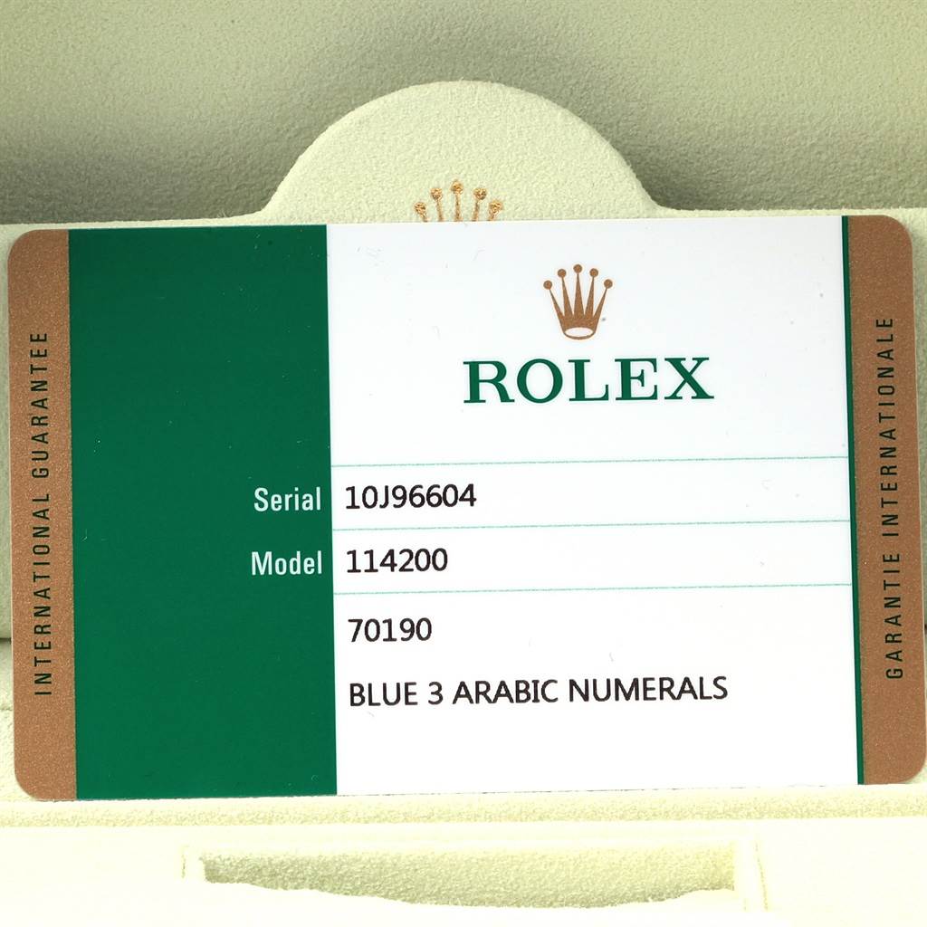 This image shows a close-up of a Rolex warranty card for the Oyster Perpetual model 114200 with serial number 10J96604.