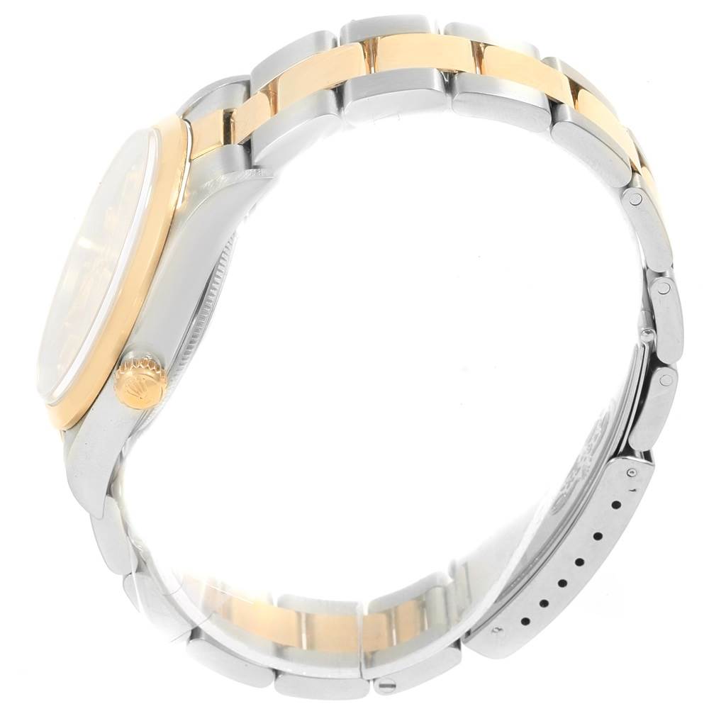 The side view of a Rolex Oyster Perpetual 14203 Men
s Steel and Gold (two tone) Champagne Dial 14203 Men
s Steel and Gold (two tone) Champagne Dial watch displays its two-tone metal bracelet and crown.