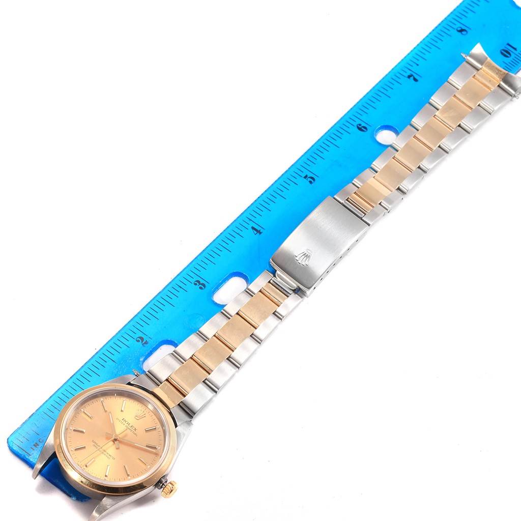 The Rolex Oyster Perpetual 14203 Men
s Steel and Gold (two tone) Champagne Dial 14203 Men
s Steel and Gold (two tone) Champagne Dial watch is shown flat with its band laid out alongside a ruler for measurement.