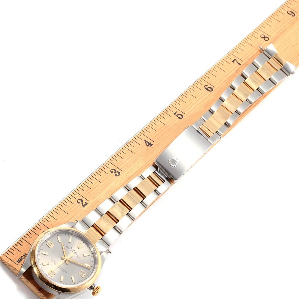 The image shows a Rolex Oyster Perpetual 14203 Men's Steel and Gold (two tone) Grey Dial 14203 Men's Steel and Gold (two tone) Grey Dial watch laid flat next to a ruler, displaying its face and two-tone bracelet.