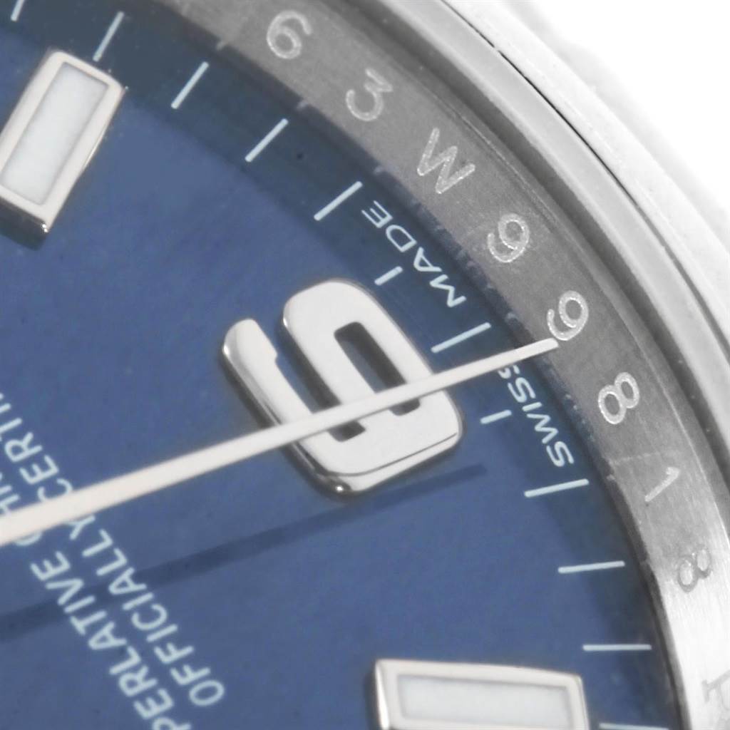 This close-up angle shows the dial and part of the hour markers of the Rolex Oyster Perpetual 114200 Men's Stainless Steel Blue Dial 114200 Men's Stainless Steel Blue Dial watch.