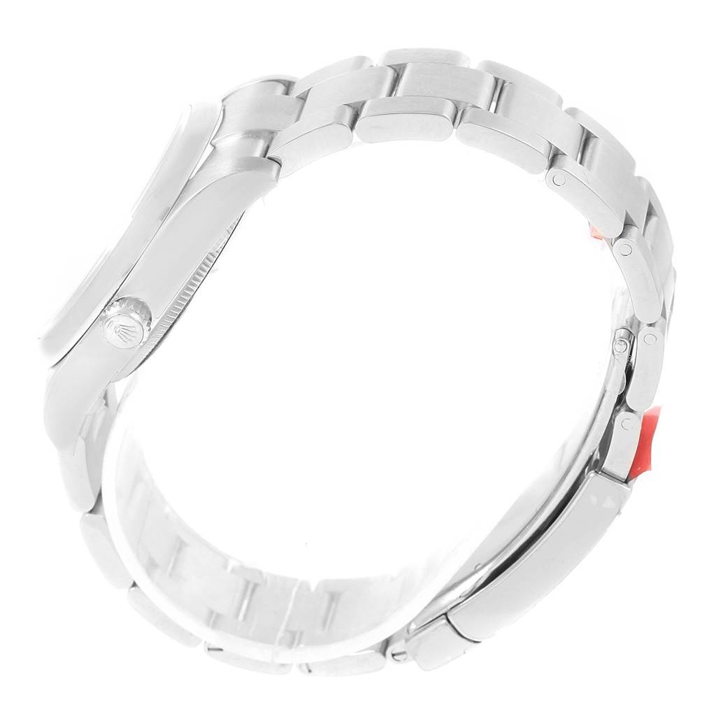 The image shows a side view of the Rolex Oyster Perpetual 114200 Men's Stainless Steel Blue Dial 114200 Men's Stainless Steel Blue Dial watch, focusing on the band and part of the watch case with the crown.