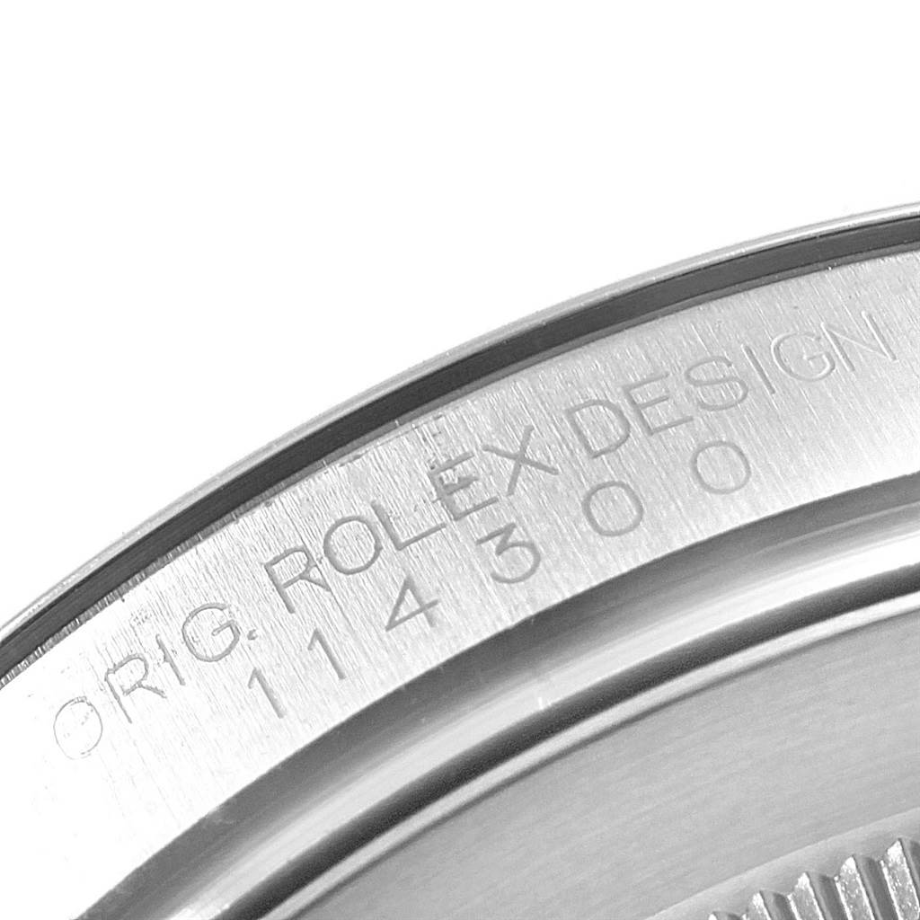 The image shows a close-up of the engraved case back of a Rolex Oyster Perpetual 114300 Men's Stainless Steel Grey Dial 114300 Men's Stainless Steel Grey Dial watch.