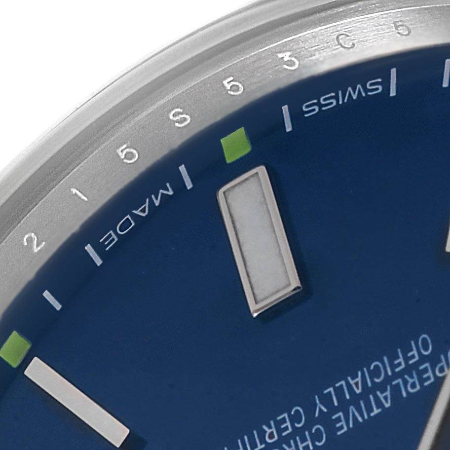 A close-up of the Rolex Oyster Perpetual 114300 Men's Stainless Steel Blue Dial 114300 Men's Stainless Steel Blue Dial watch face, showing the hour markers, partial logo, and "Swiss Made" text.