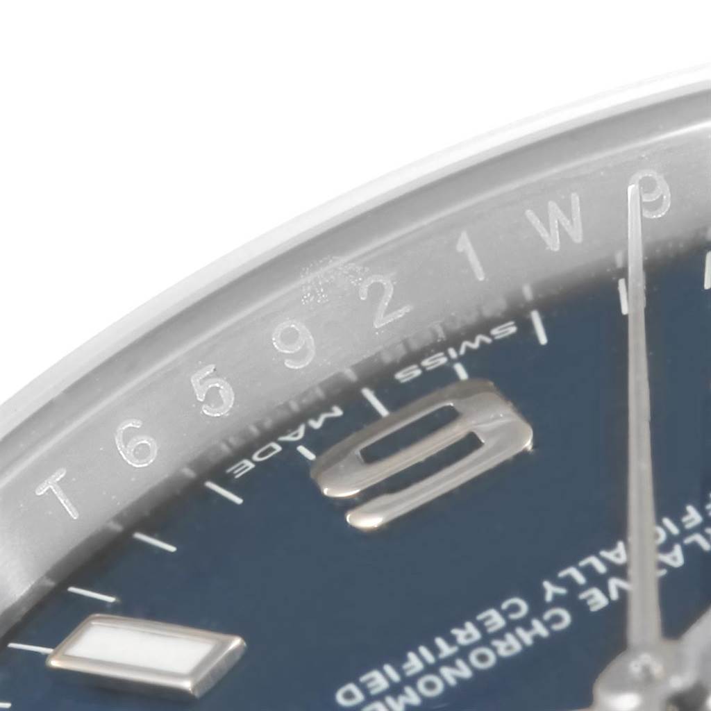This is a close-up of the dial and outer edge of a Rolex Oyster Perpetual 114200 Men's Stainless Steel Blue Dial 114200 Men's Stainless Steel Blue Dial watch, showing the numerals and part of the minute hand.