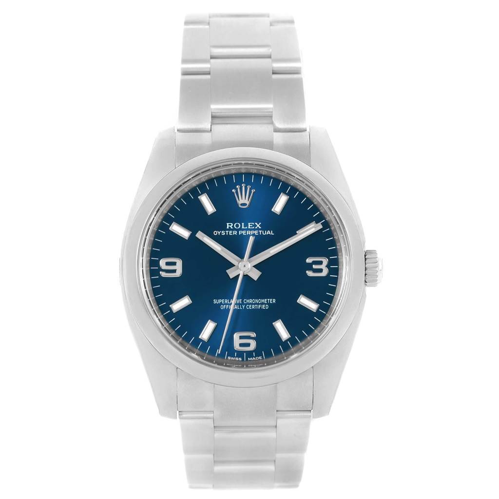 The Rolex Oyster Perpetual 114200 Men's Stainless Steel Blue Dial 114200 Men's Stainless Steel Blue Dial watch is shown from a front angle, displaying the face, bezel, crown, and part of the bracelet.