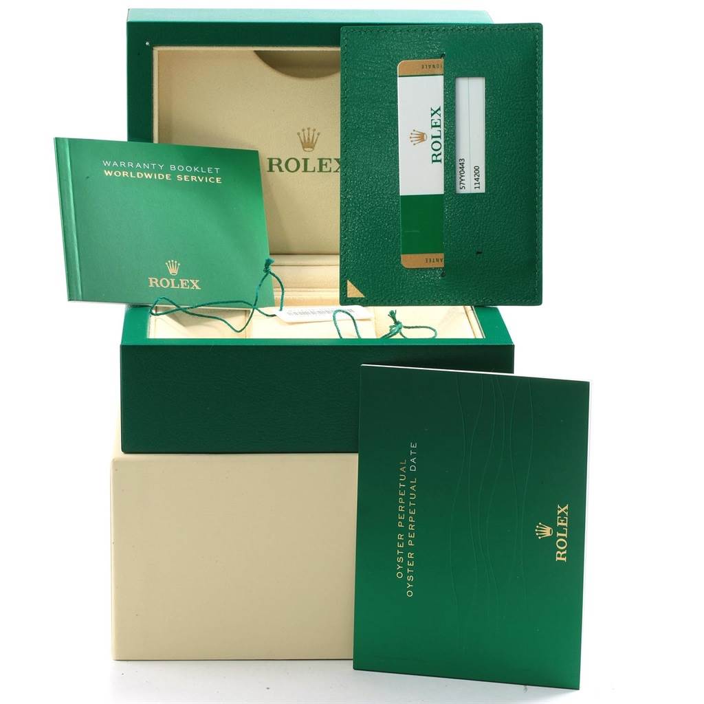 The image shows the box, warranty booklets, and accessories for the Rolex Oyster Perpetual 114200 Men's Stainless Steel Silver Dial 114200 Men's Stainless Steel Silver Dial watch from a front angle.