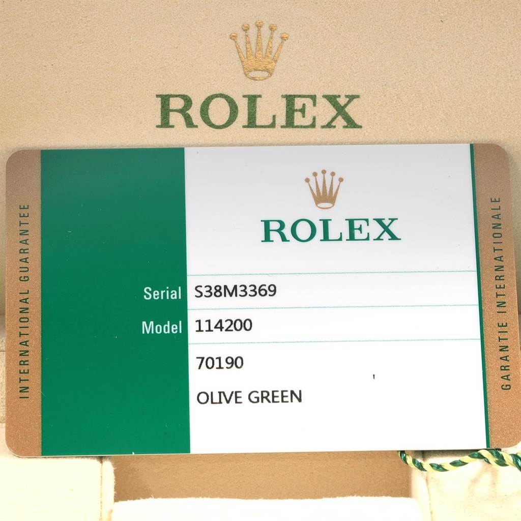 The image shows the warranty card for a Rolex Oyster Perpetual 114200 Men's Stainless Steel Green Dial 114200 Men's Stainless Steel Green Dial model 114200 in olive green.