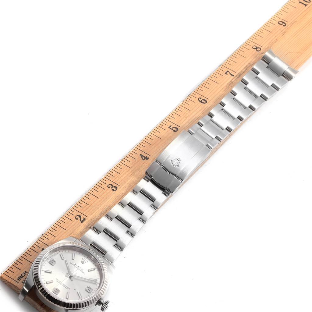 The image shows a top-down view of a Rolex Oyster Perpetual 116034 Men's Stainless Steel Silver Dial 116034 Men's Stainless Steel Silver Dial watch, showcasing the dial, bracelet, and clasp with a ruler for scale.