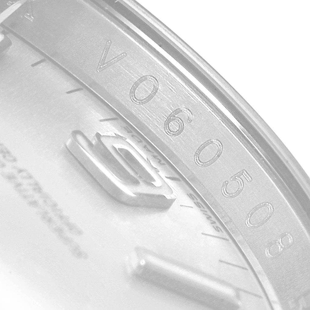 This image shows a close-up of the serial number inscribed on the dial of a Rolex Oyster Perpetual 116034 Men's Stainless Steel Silver Dial 116034 Men's Stainless Steel Silver Dial watch.