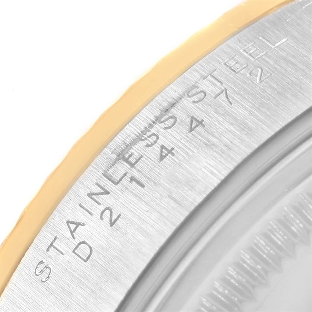 This close-up image shows a partial view of the bezel and case back of a Rolex Oyster Perpetual 14233 Men's Steel and Gold (two tone) Champagne Dial 14233 Men's Steel and Gold (two tone) Champagne Dial watch, highlighting the engraved text.