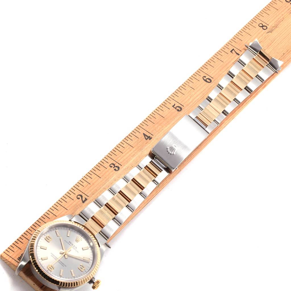 The image shows a Rolex Oyster Perpetual 14233 Men
s Steel and Gold (two tone) Grey Dial 14233 Men
s Steel and Gold (two tone) Grey Dial watch lying flat with a wooden ruler for scale.