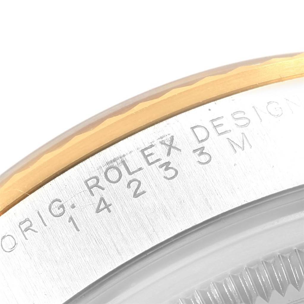 This image shows a close-up of the bezel and engraved serial number of a Rolex Oyster Perpetual 14233 Men's Steel and Gold (two tone) Blue Dial 14233 Men's Steel and Gold (two tone) Blue Dial watch.