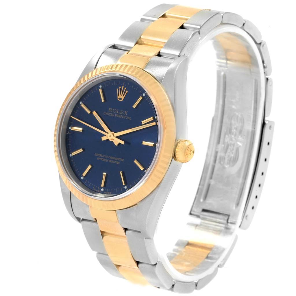 This image shows a Rolex Oyster Perpetual 14233 Men's Steel and Gold (two tone) Blue Dial 14233 Men's Steel and Gold (two tone) Blue Dial watch at an angle highlighting its blue dial, gold bezel, and two-tone metal bracelet.