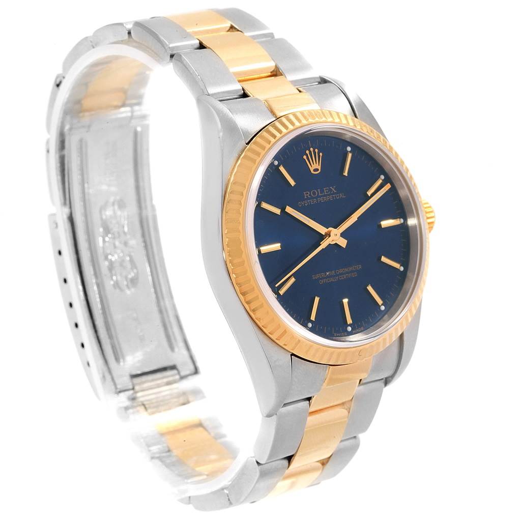 This Rolex Oyster Perpetual 14233 Men's Steel and Gold (two tone) Blue Dial 14233 Men's Steel and Gold (two tone) Blue Dial watch is shown at a three-quarter angle, highlighting its dial, bezel, and bracelet.