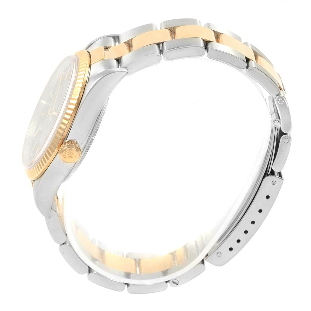 This image shows a side view of the Rolex Oyster Perpetual 14233 Men's Steel and Gold (two tone) Blue Dial 14233 Men's Steel and Gold (two tone) Blue Dial watch, highlighting its crown, bezel, and two-tone bracelet.