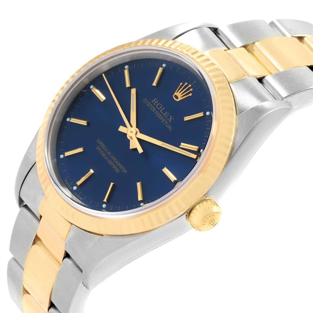 This image shows a close-up angle of the Rolex Oyster Perpetual 14233 Men's Steel and Gold (two tone) Blue Dial 14233 Men's Steel and Gold (two tone) Blue Dial watch, highlighting its blue dial, gold bezel, and two-tone bracelet.