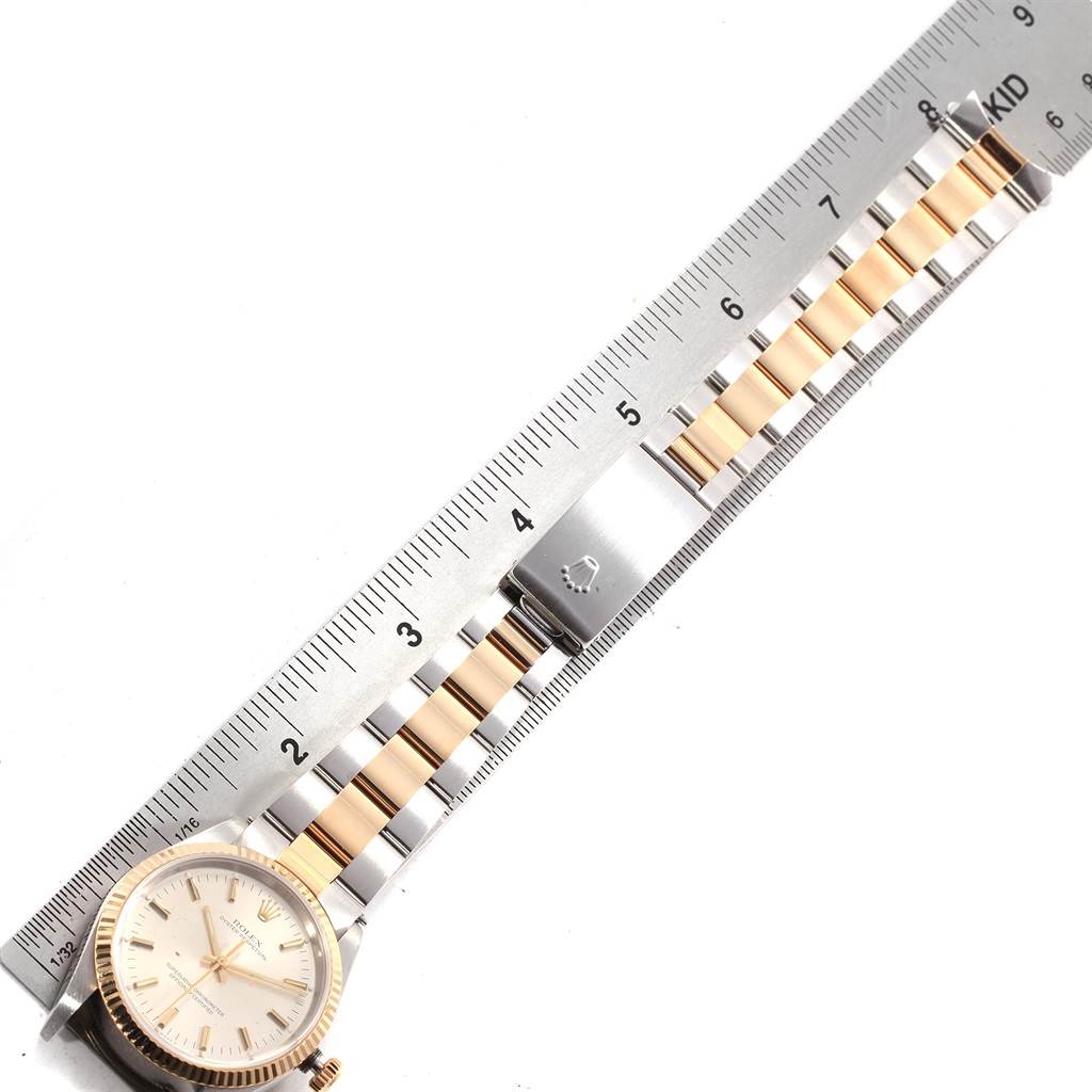 The image shows a top-down view of a Rolex Oyster Perpetual 14233 Men's Steel and Gold (two tone) Silver Dial 14233 Men's Steel and Gold (two tone) Silver Dial watch with a two-tone metal bracelet, measured against a steel ruler.