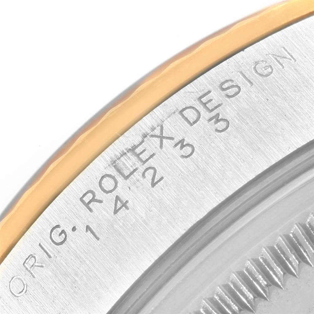 This image shows a close-up of the edge of a Rolex Oyster Perpetual 14233 Men's Steel and Gold (two tone) Silver Dial 14233 Men's Steel and Gold (two tone) Silver Dial watch, highlighting the bezel and engraving.
