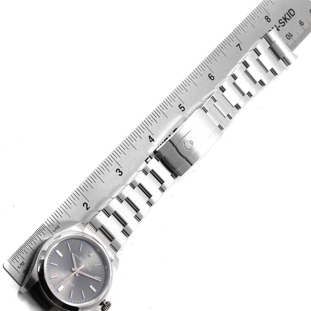 This image shows a top-down view of a Rolex Oyster Perpetual 114300 Men
s Stainless Steel Grey Dial 114300 Men
s Stainless Steel Grey Dial watch and its bracelet aligned with a ruler for measurement.