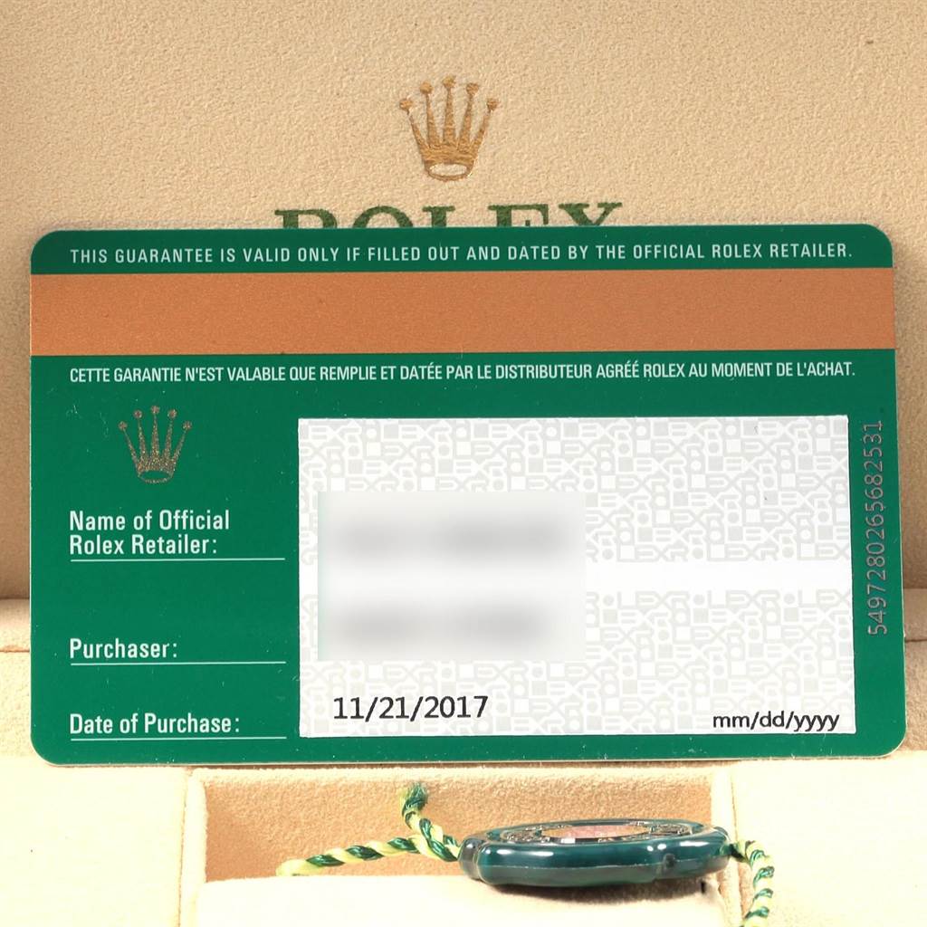 The image displays a close-up of a Rolex warranty card with a portion of the Oyster Perpetual watch's case and tag visible below.