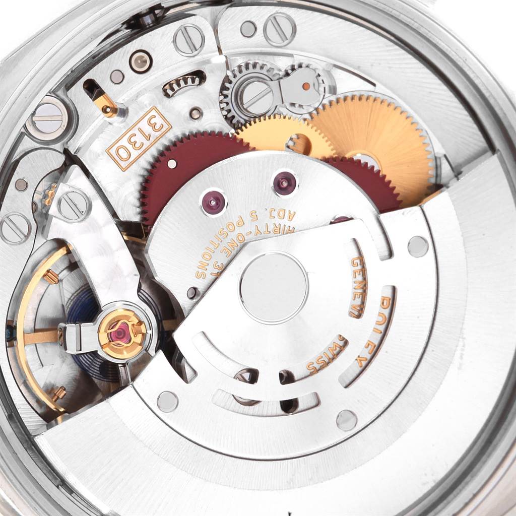 This image shows a close-up view of the internal mechanism of a Rolex Oyster Perpetual 114200 Stainless Steel Green Dial 114200 Stainless Steel Green Dial watch, highlighting gears and intricate parts.