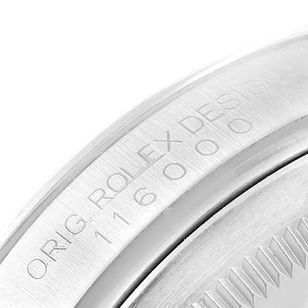 This close-up image shows the engraved case back of a Rolex Oyster Perpetual 116000 Men's Stainless Steel Black Dial 116000 Men's Stainless Steel Black Dial watch.