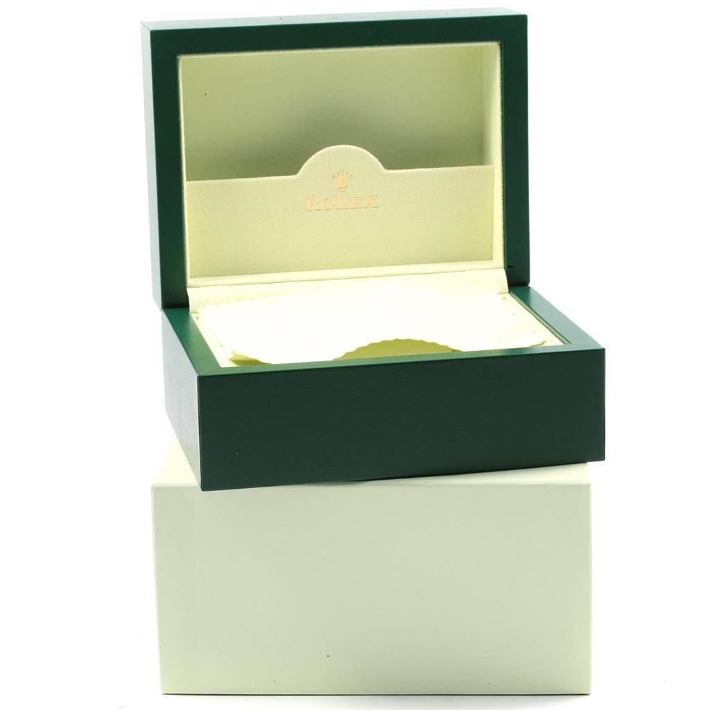 The image shows an open green and beige Rolex box for the Oyster Perpetual model.