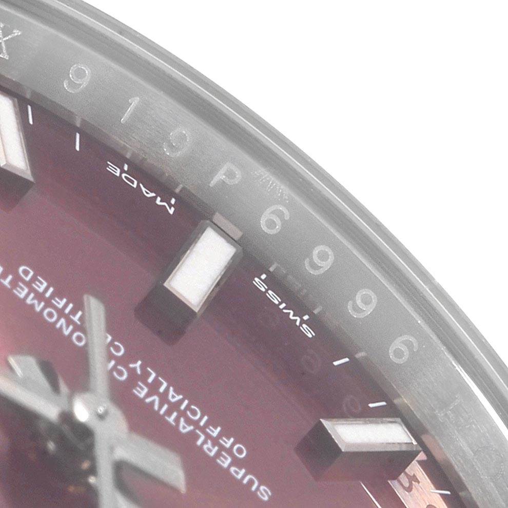 This close-up of a Rolex Oyster Perpetual 114200 Stainless Steel Burgundy Dial 114200 Stainless Steel Burgundy Dial watch shows part of the dial, hour markers, and a portion of the hands.