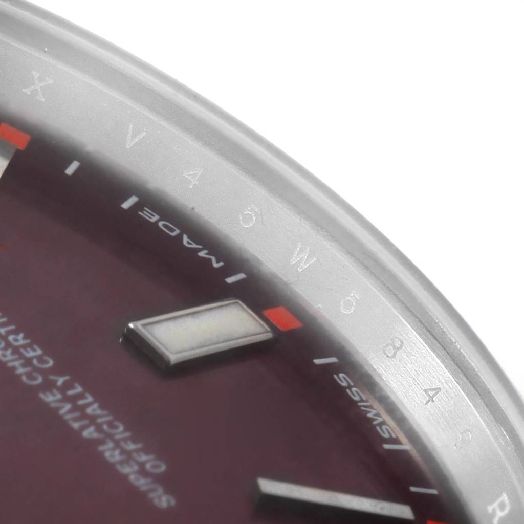 The close-up image of the Rolex Oyster Perpetual 114300 Men's Stainless Steel Burgundy Dial 114300 Men's Stainless Steel Burgundy Dial watch shows part of the dial, markers, and outer edge of the watch face.