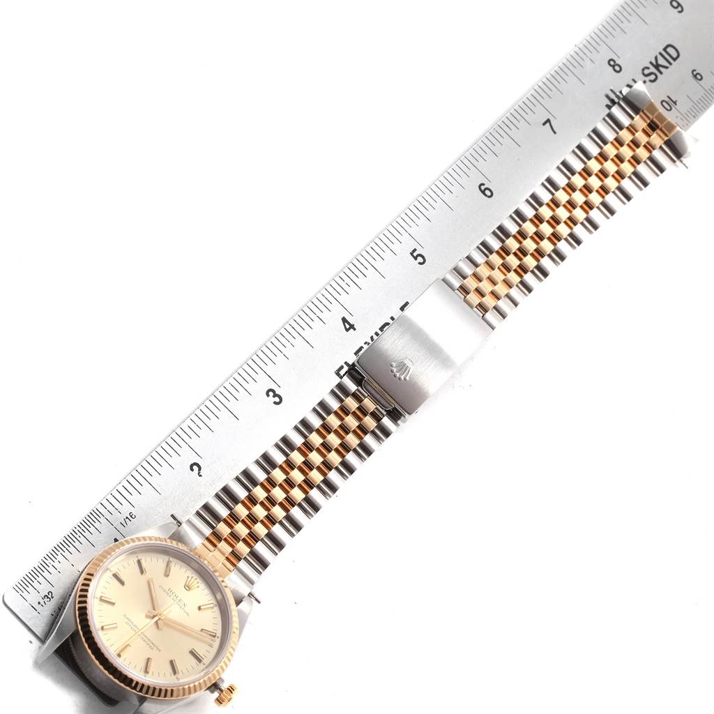 The image shows a Rolex Oyster Perpetual 14233 Men's Steel and Gold (two tone) Champagne Dial 14233 Men's Steel and Gold (two tone) Champagne Dial watch laid flat with a metal ruler beside it, highlighting the watch face, crown, and two-tone bracelet.