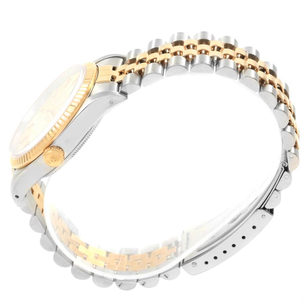 The image shows the side view of a Rolex Oyster Perpetual 14233 Men's Steel and Gold (two tone) Champagne Dial 14233 Men's Steel and Gold (two tone) Champagne Dial watch, highlighting its two-tone bracelet and crown.