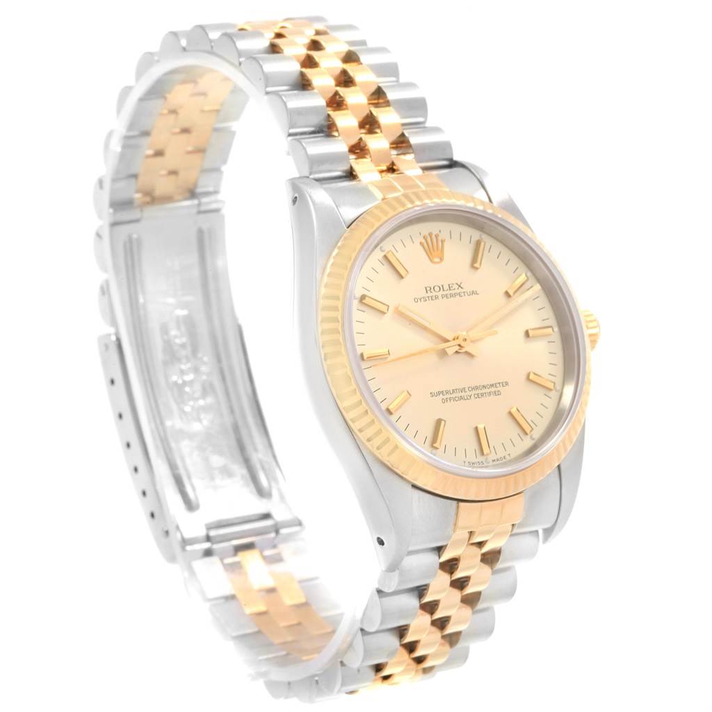 The Rolex Oyster Perpetual 14233 Men's Steel and Gold (two tone) Champagne Dial 14233 Men's Steel and Gold (two tone) Champagne Dial watch is shown from an angled view, highlighting its two-tone bracelet, bezel, and dial.