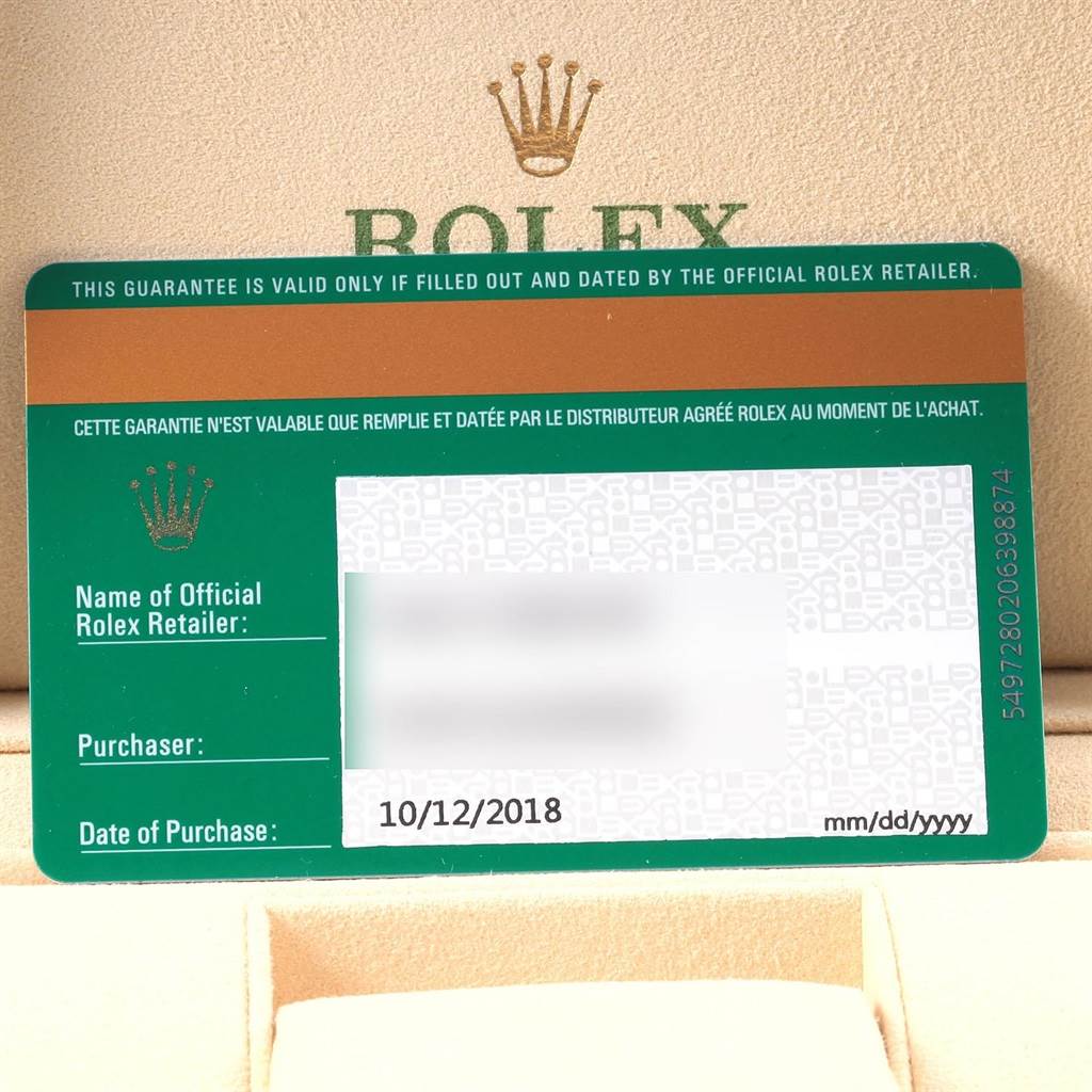 The image shows a guarantee card for a Rolex Oyster Perpetual 114200 Men
s Stainless Steel Burgundy Dial 114200 Men
s Stainless Steel Burgundy Dial watch, including the date of purchase and retailer information.